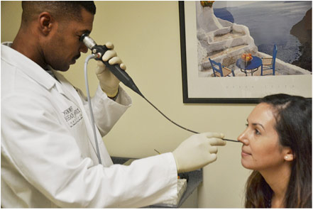 Figure 2: Flexible fiberoptic laryngoscopy (FFL) examination where the scope is inserted through the nose. The physician must look through the eyepiece in order to see the image.